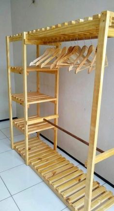 a wooden shelf with clothes hanging on it's sides and shelves underneath the shelf