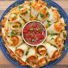 a blue plate topped with tortillas covered in sauce