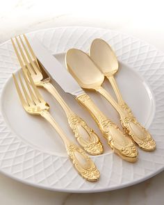 a white plate topped with gold colored utensils