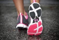 there is a woman's feet in pink and black running shoes