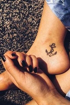 a woman's foot with an anchor tattoo on it