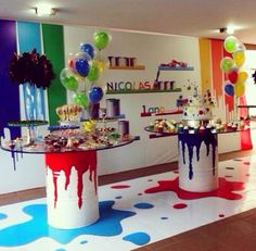 a room filled with lots of colorful balloons and cake on top of tables covered in confetti