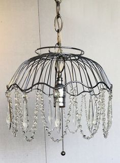 a chandelier hanging from the ceiling with crystal beads and chains attached to it