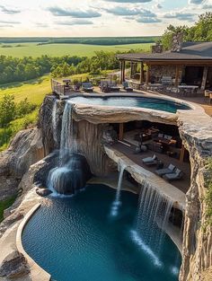 an aerial view of a house with a pool and waterfall in the middle of it