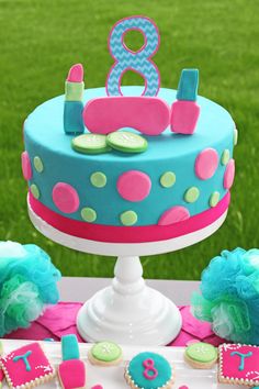 a blue and pink birthday cake sitting on top of a table