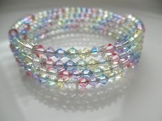 "\"GLAMOROUS!\" Pastel Rainbow Crystal Memory Wire Bracelet with Silver Accent ONE SIZE FITS MOST Composition: Premium top-of-the-line European crystals in soft pastel-colored bicone crystals of light yellow, light green(AB), light blue, light pink, light purple and clear AB accentuated by interspersed silver daisy spacers. 2.5\" diameter stainless steel memory wire It wraps around the wrist 4 times and will retain it's slinky shape. Easy on - easy off! The bracelet ends are looped. This item wi Bracelet Ends, Memory Wire Jewelry, Bracelet For Her, Wire Bracelets, Spring Bracelet, Memory Wire Bracelet, Memory Wire Bracelets, Crystal Beads Bracelet, Beaded Bracelets Diy