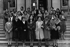 a group of women standing in front of a building