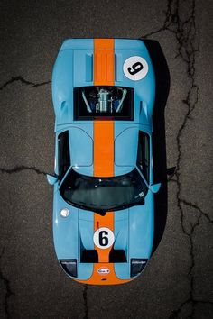 an overhead view of a blue and orange race car with numbers 6 on it's side