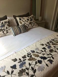 a bed with white sheets and pillows on top of it