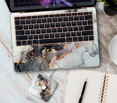 an open laptop computer sitting on top of a desk next to a cup of coffee