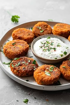 some food is on a plate with a dip in the middle and garnished with parsley