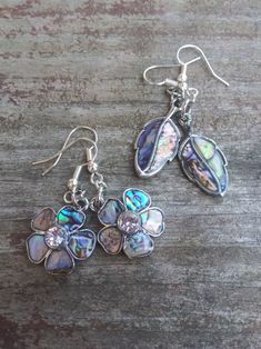 These earrings feature a colorful abalone shell design. Silver Abalone Shell Earrings, Silver Abalone Shell Earrings Gift, Abalone Shell Earrings For Pierced Ears As A Gift, Gift Abalone Shell Earrings, Gift Abalone Shell Earrings For Pierced Ears, Shell-shaped Metal Earrings For Gift, Handmade Silver Abalone Shell Earrings, Nickel-free Abalone Shell Earrings For Gift, Silver Drop Earrings With Abalone Shell