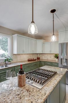 This refresh took some of the kitchen's already nice features (the layout, backsplash, countertops) and updated it to make the client's style even better. 
All cabinet doors, including the cabinetry around the island was all updated. They ended up going with the green for the lower cabinets and the island. For the upper cabinets, they chose a very subtle and lighter shade of green; still drawing in colors from the countertop and tying in the dark green from the lower cabinets. Cream And Sage Kitchen Cabinets, Blue Cabinets With Brown Granite, Green Kitchen Cabinets With Brown Countertops, Green Cabinets Tan Countertops, Kitchen Cabinet Color Ideas With Granite Countertops, Green Cabinets With Brown Countertops, Light Green Lower Kitchen Cabinets, Green Cabinets Dark Countertops, Sage Green Lowers White Uppers