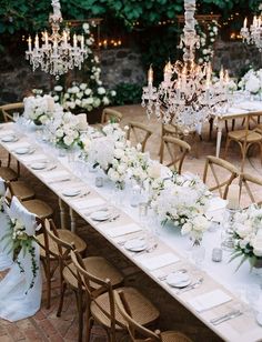 a long table is set with white flowers and candles