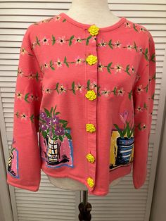 "Hand painted cotton cardigan sweater  Salmon pink w/ multicolored flowers and bright yellow daisy buttons Spring weight boho kitchy cardigan. Appears never worn. Ready to swing into spring in this fun cardigan Shoulder 17 1/2\" Chest 21\" pit to pit (42\" buttoned) Length 21 1/2\" bottom of neck to hem Sleeve 21 1/2\" ( 25 1/4\" from neck) Hem 42\" Buttons 6" Spring Multicolor Sweater With Button Closure, Vintage Floral Print Spring Cardigan, Spring Cotton Cardigan With Floral Print, Multicolor Button Sweater For Spring, Spring Floral Print Cotton Cardigan, Yellow Retro Cardigan For Spring, Retro Yellow Cardigan For Spring, Pink Bohemian Cotton Cardigan, Spring Yellow Buttoned Cardigan