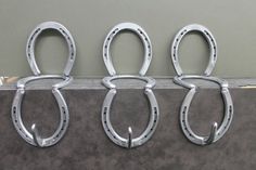 three horseshoes are hanging on the side of a wall