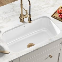 a white sink sitting on top of a counter next to a cutting board and knife