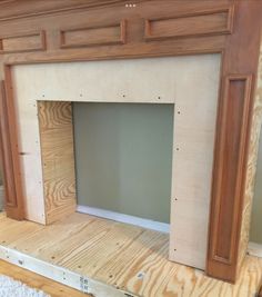 an unfinished fireplace surround being built with plywood