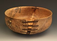 a wooden bowl with designs on it