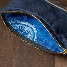 an open zippered pouch sitting on top of a wooden floor