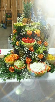 a table topped with lots of different types of fruits and flowers on top of each other