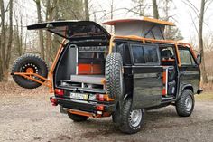 an orange and black vehicle parked in the woods