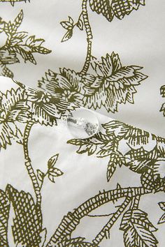 an image of a white and green fabric with leaves on it