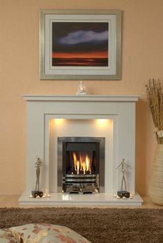 a living room with a fire place in the center and pictures on the wall above it