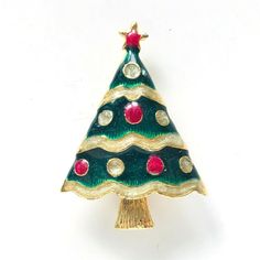 a green and gold christmas tree brooch with red, white, and blue decorations