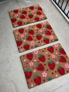 three door mats with strawberries and flowers on them