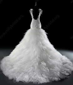 a white wedding dress on display in front of a black background