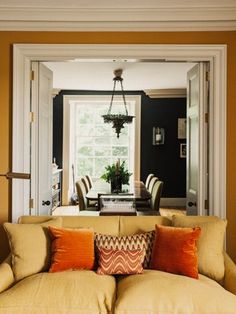 a living room filled with furniture next to a dining room table and chairs in front of a window