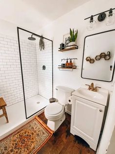 a bathroom with a toilet, sink and shower stall in it's own area