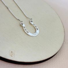 Add a touch of elegance and good luck to your jewelry collection with this custom Horseshoe Necklace. Crafted in high-quality sterling silver, this personalized necklace features a beautifully crafted horseshoe pendant, engraved with a word or name in an elegant font. The horseshoe is a timeless symbol of luck and protection. Wearing a horseshoe pendant is believed to bring good fortune and safeguard the wearer from negative energy. Our horseshoe pendant necklace makes a thoughtful and meaningfu Sterling Silver Horseshoe Necklace For Gifts, Personalized Silver Horseshoe Jewelry, Horseshoe Shaped Sterling Silver Necklaces, Silver Sterling Silver Horseshoe Necklace, Symbol Of Luck, Necklace For Girls, Horseshoe Pendant, Horseshoe Necklace, Timeless Symbol