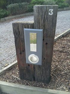 two wooden posts with a mirror on them in the middle of some grass and dirt