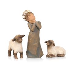 a figurine of a child and two lambs with a crown on their head