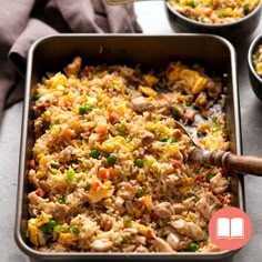 a pan filled with rice, meat and vegetables