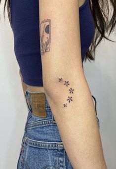 a woman with a small tattoo on her arm, showing the back of her left arm