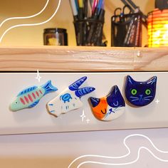 three magnets with cats and fish on them