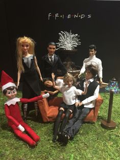 a group of dolls sitting on top of a chair in front of a sign that says friends