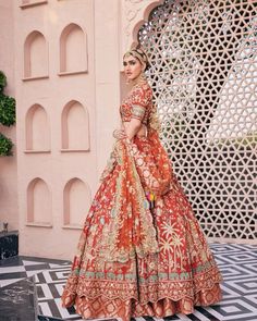 a woman in an orange and gold wedding dress