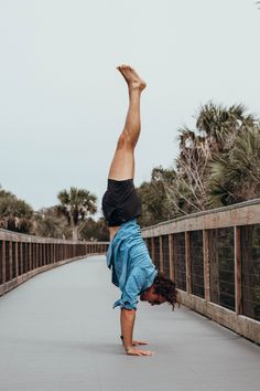 a person doing a handstand on a bridge