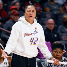 a women's basketball player wearing a white hoodie