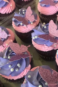 cupcakes with pink and purple frosting decorated with butterfly wings, pearls and beads