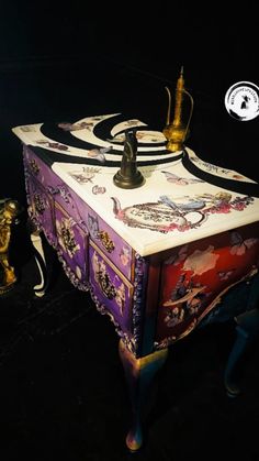 an ornately painted chest with two candles on it's top and one candle holder in the middle