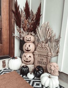 pumpkins and other halloween decorations on the front porch