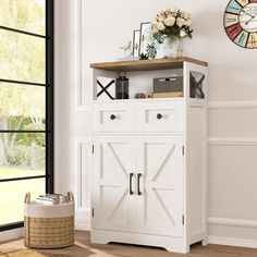 a white cabinet sitting in the corner of a room with a clock on the wall