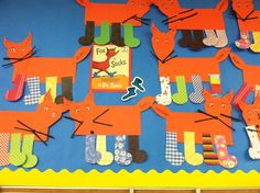 a bulletin board with lots of orange cats on it's sides and some books in the back