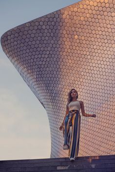 a woman standing on the side of a building