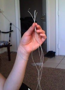 a person holding something in their hand while sitting on the floor